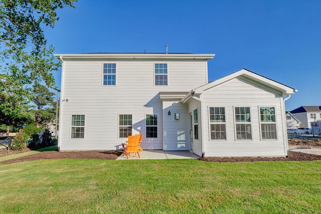 back of house with a patio and a lawn