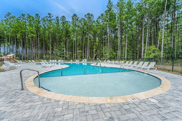 community pool featuring a patio area and fence