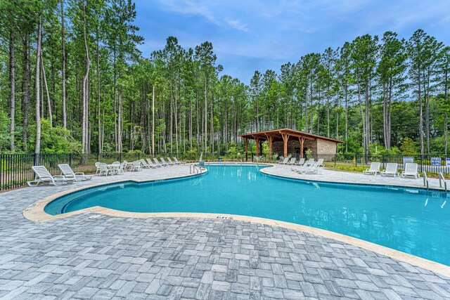 pool with a patio area and fence