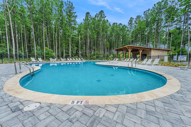 pool featuring fence and a patio