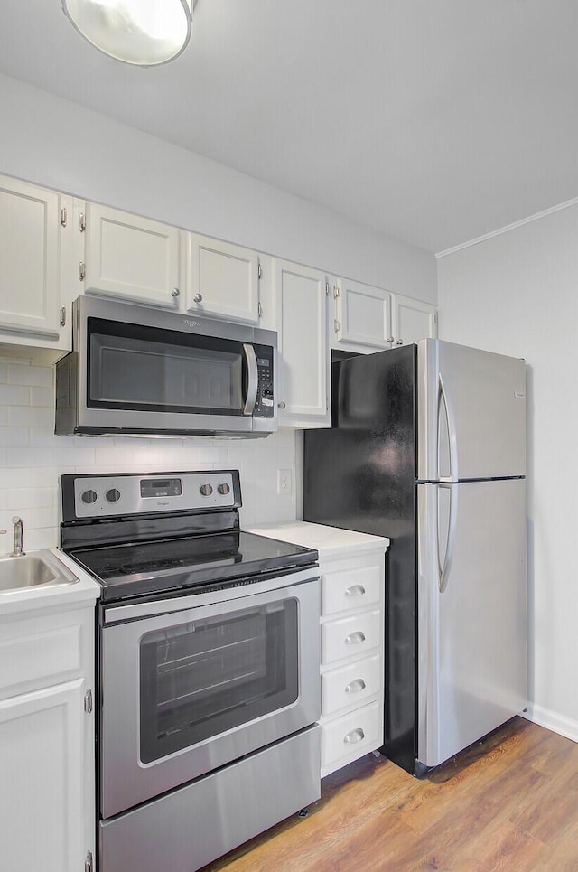 259 E Bay St Unit 7C, Charleston, SC 29401 - kitchen with stainless steel appliances, white cabinets, and tasteful backsplash