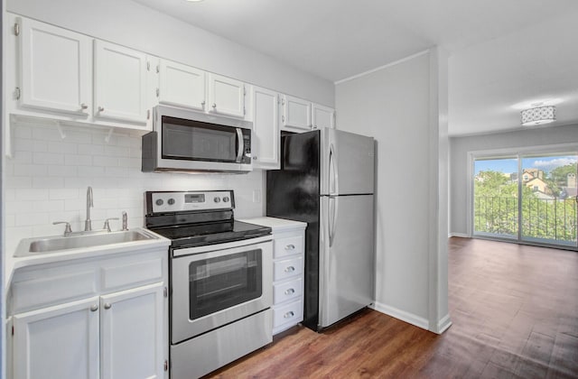 259 E Bay St Unit 7C, Charleston, SC 29401 - kitchen featuring stainless steel appliances, a sink, white cabinets, backsplash, and dark wood-type flooring