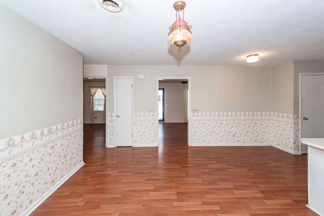 spare room with baseboards, visible vents, light wood finished floors, and wallpapered walls