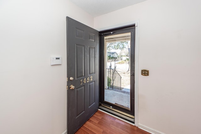 foyer entrance featuring baseboards and dark wood-style flooring