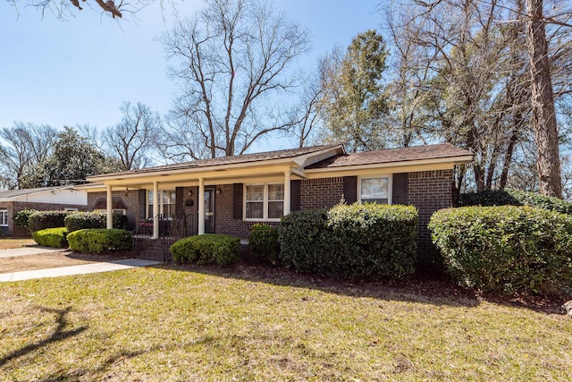 ranch-style house featuring covered porch, a front lawn, and brick siding