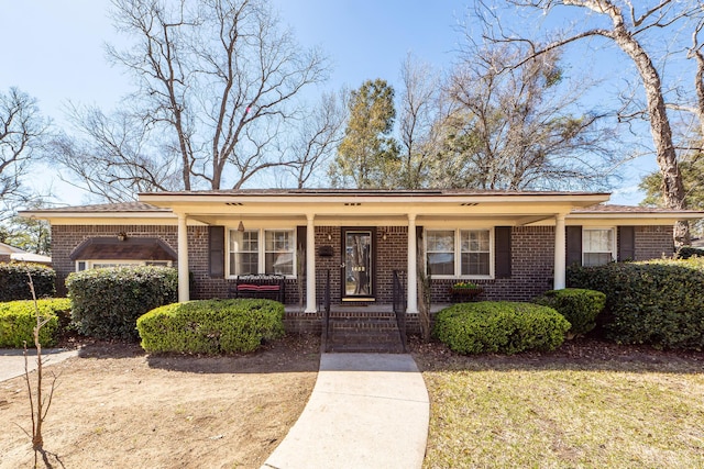 view of front of house with a porch and brick siding