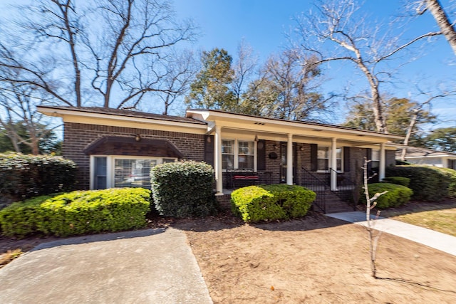 view of front of home with a porch and brick siding