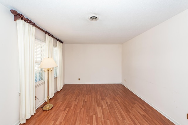 unfurnished room with baseboards, visible vents, and light wood-style floors