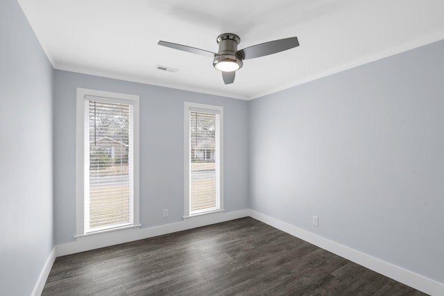 unfurnished room with dark wood finished floors, visible vents, ornamental molding, ceiling fan, and baseboards