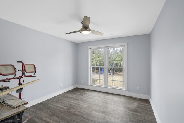 empty room featuring a ceiling fan, baseboards, and wood finished floors