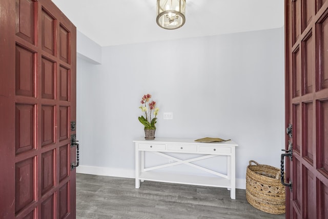 entryway featuring a notable chandelier, baseboards, and wood finished floors