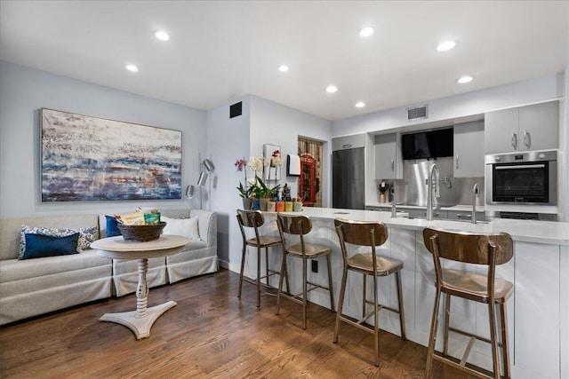 1481 Center Street Ext Unit 1102, Mount Pleasant, SC 29464 - kitchen featuring light countertops, a peninsula, a breakfast bar area, recessed lighting, and fridge
