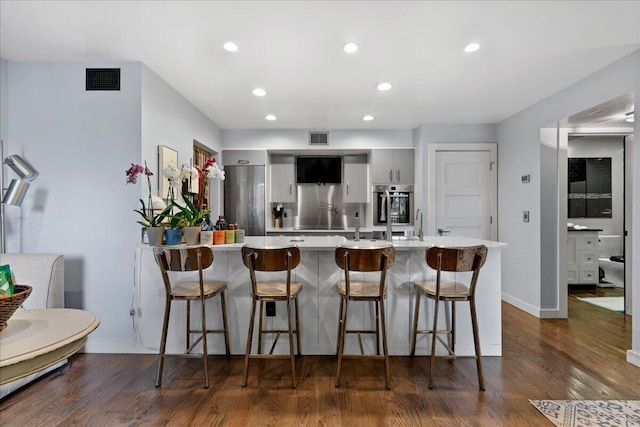 1481 Center Street Ext Unit 1102, Mount Pleasant, SC 29464 - kitchen featuring light countertops, a breakfast bar area, stainless steel appliances, dark wood finished floors, and recessed lighting