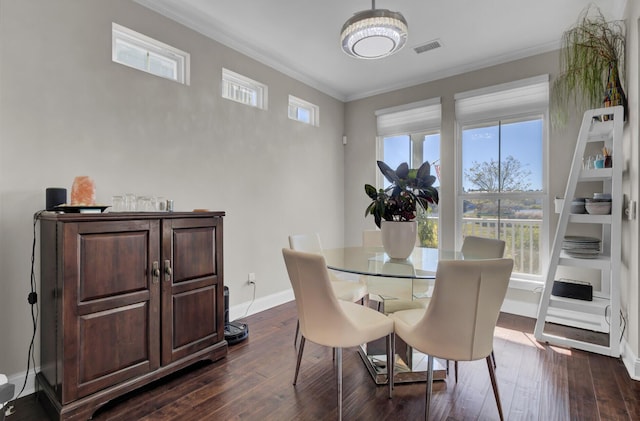 dining area with visible vents, dark wood finished floors, and crown molding