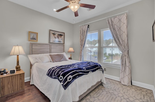 bedroom featuring ceiling fan, wood finished floors, and baseboards