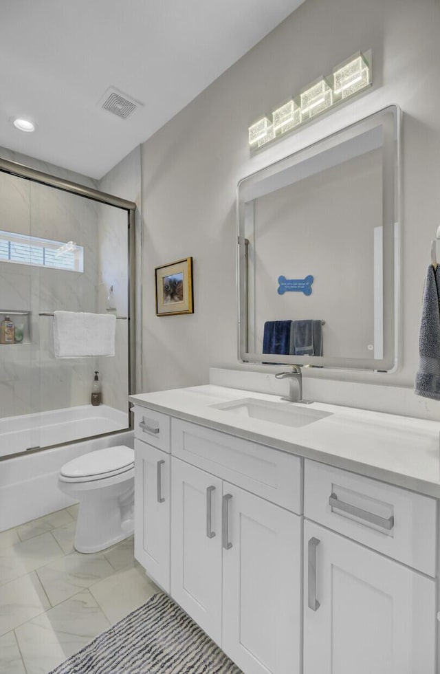 bathroom featuring toilet, vanity, visible vents, marble finish floor, and combined bath / shower with glass door