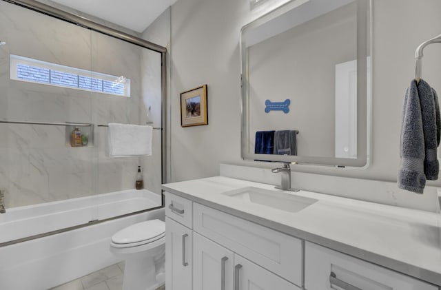 bathroom featuring toilet, enclosed tub / shower combo, and vanity