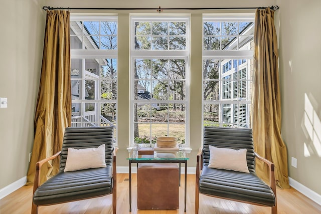 sitting room with baseboards and wood finished floors