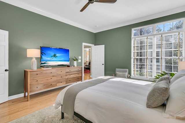 bedroom featuring ornamental molding, multiple windows, wood finished floors, and baseboards