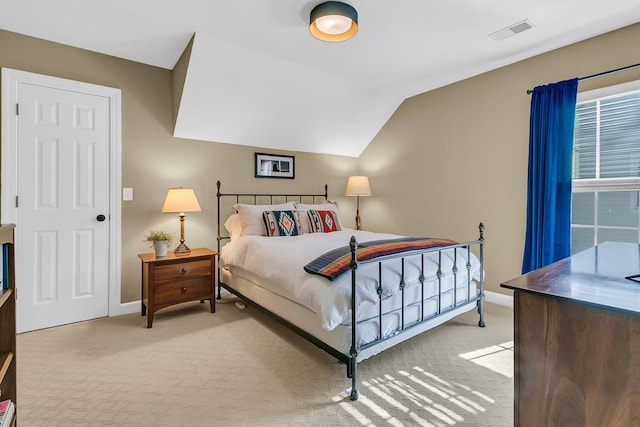 bedroom with light carpet, lofted ceiling, visible vents, and baseboards