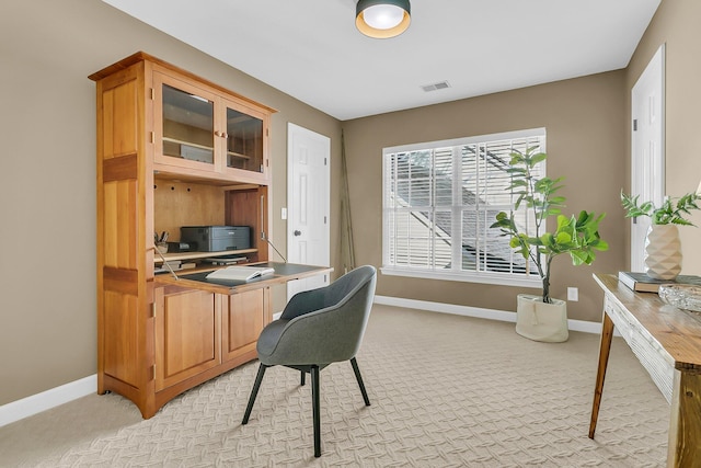 office featuring visible vents, baseboards, and light colored carpet