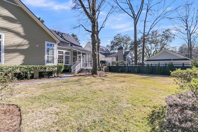 view of yard with a sunroom and fence