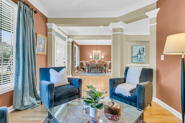 living area with ornamental molding, light wood-type flooring, decorative columns, and baseboards