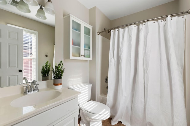 full bathroom with shower / tub combo with curtain, vanity, and toilet