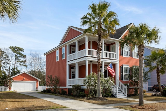 view of front of home featuring covered porch, a balcony, a garage, and an outdoor structure