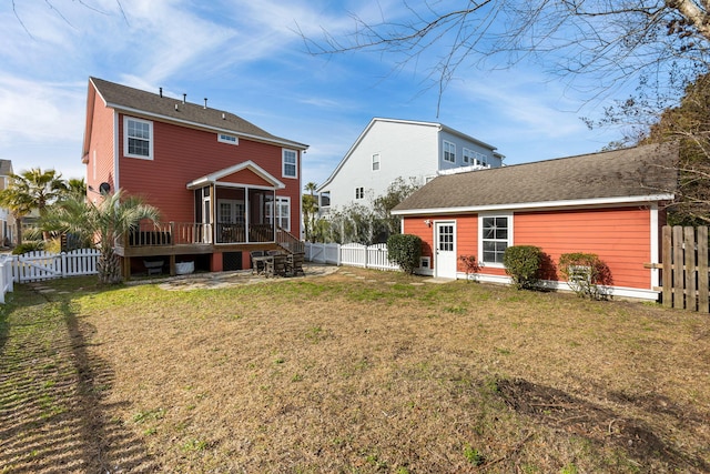 rear view of property featuring a deck and a yard