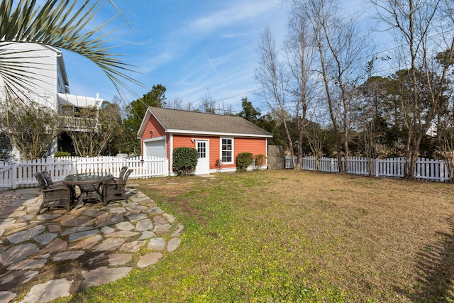 view of yard with a patio, an outbuilding, and a garage