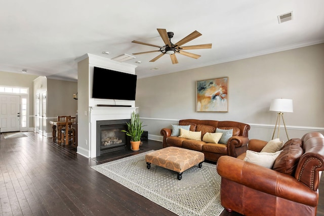 living room featuring ornamental molding, ceiling fan, and dark hardwood / wood-style floors