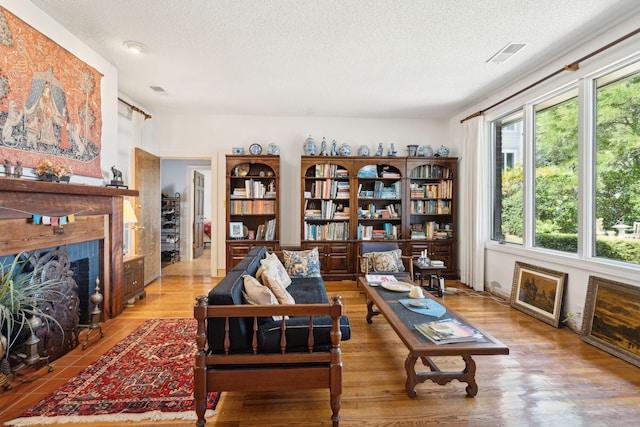 528 Wampler Dr, Charleston, SC 29412 - living area featuring a fireplace with flush hearth, healthy amount of natural light, a textured ceiling, and wood finished floors
