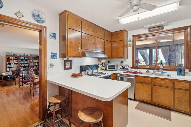 528 Wampler Dr, Charleston, SC 29412 - kitchen with dishwasher, white gas stove, a sink, under cabinet range hood, and brown cabinets