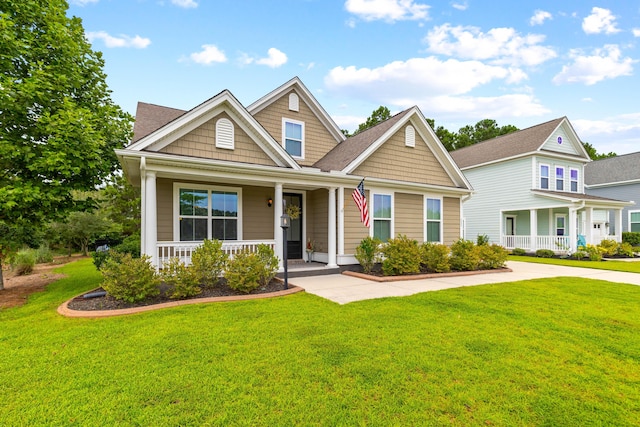 craftsman inspired home featuring covered porch and a front lawn