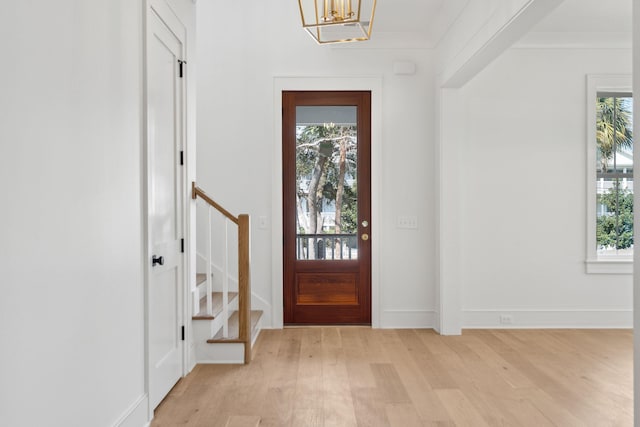 entryway with crown molding, stairway, and a healthy amount of sunlight