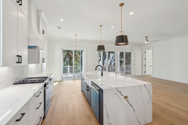 kitchen featuring white cabinets, decorative backsplash, stainless steel appliances, crown molding, and light wood-type flooring