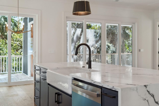 kitchen with dishwasher, hanging light fixtures, a sink, and light stone countertops