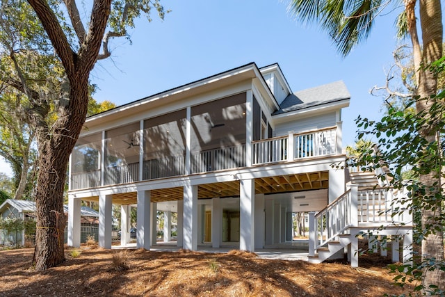 view of front of home featuring a carport, a sunroom, and stairs