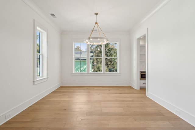 unfurnished dining area featuring light wood-style floors, visible vents, and ornamental molding