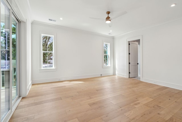 spare room with ornamental molding, light wood-type flooring, visible vents, and baseboards