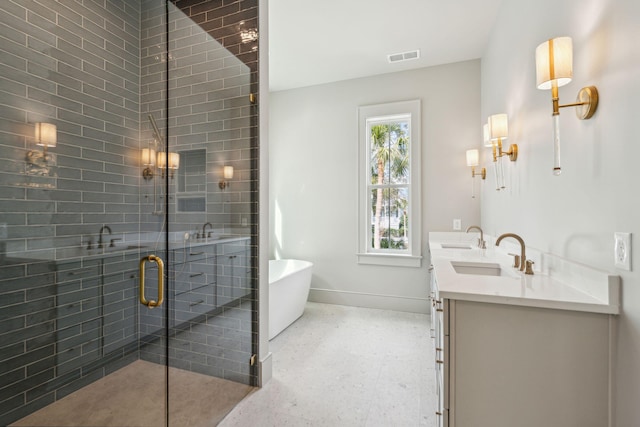 full bathroom featuring a sink, baseboards, a soaking tub, a shower stall, and double vanity