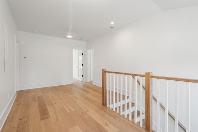 hallway featuring baseboards, recessed lighting, an upstairs landing, and light wood-style floors