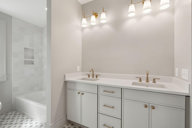 bathroom with baseboards, a sink, toilet, and double vanity