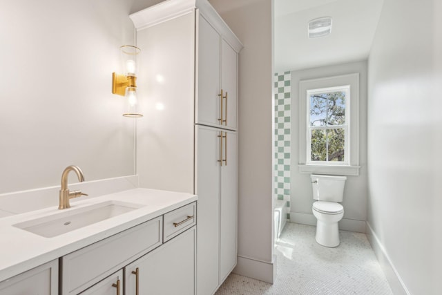 full bath featuring vanity, toilet, and baseboards