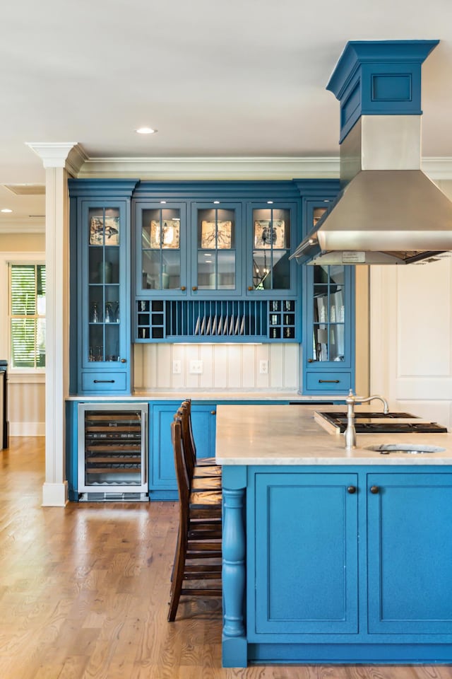 bar featuring light wood-style floors, ornamental molding, island exhaust hood, and wine cooler