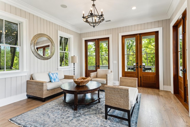 sunroom / solarium featuring an inviting chandelier, plenty of natural light, and french doors
