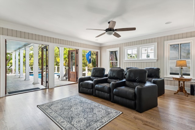 living area with ornamental molding, a ceiling fan, and wood finished floors