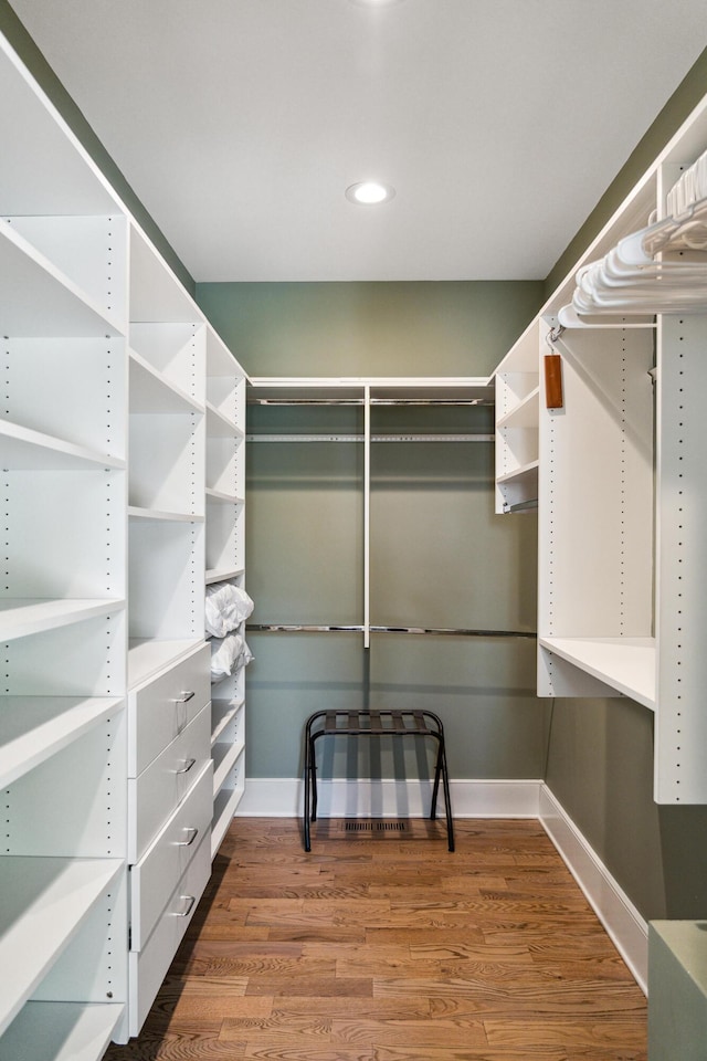 walk in closet with wood finished floors