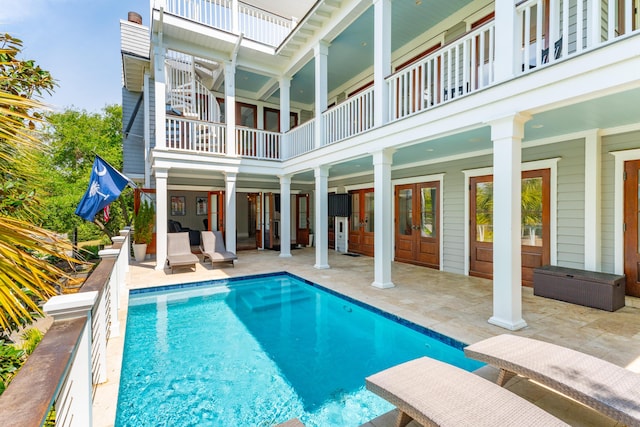 pool with french doors and a patio area